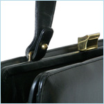 Trim, black leather handbag with classical music theme 