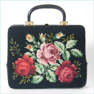 Colorful, Rosenfeld handbag with chunky gold plated hardware and needlepoint side panels with red and pink roses  black faille lined interior has two large slip pockets and one zippered pocket; has a matching little coin purse and small mirror  marked; “Rosenfeld”  12.75” w x 3.5” d x 10.25” h, 13.5” h to top of handle  excellent condition, slight bend to leather handle  $350. 