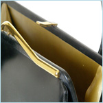 black leather handbag with exaggerated taper to arching handle